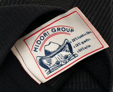 Label with 'Midori Group' branding and a cat illustration on a dark fabric background